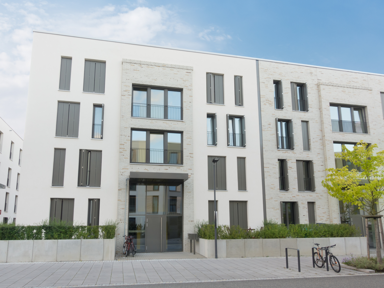 Strak modern wit appartementencomplex met schone gevels en grote raampartijen.